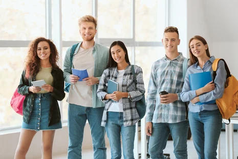 Das Bild stellt 5 junge Menschen mit Rucksack und Schulsachen in der Hand dar.
