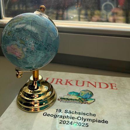 Urkunde des 19. Regionalfinales der Geographieolympiade und ein Globus