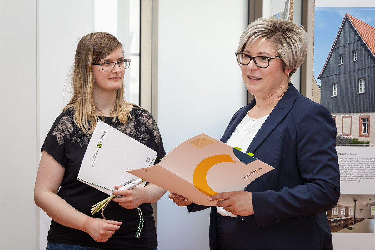 Foto von der Vermessungsoberinspektorin Isabell Rusch und die Beigeordnete des Landkreises Bautzen Dr. Romy Reinisch bei der Vertragsübergabe